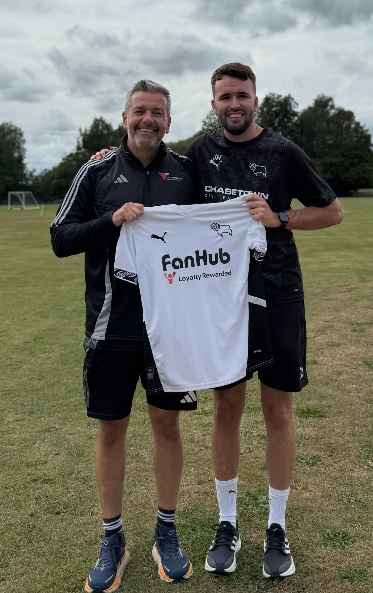 Rusty with a player holding a Derby County shirt
